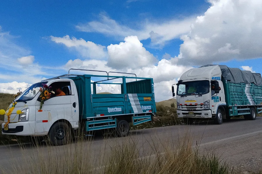 Dos unidades livianas de estacas de Quechua Express, las de los envíos urgentes y críticos, en una carretera de altura